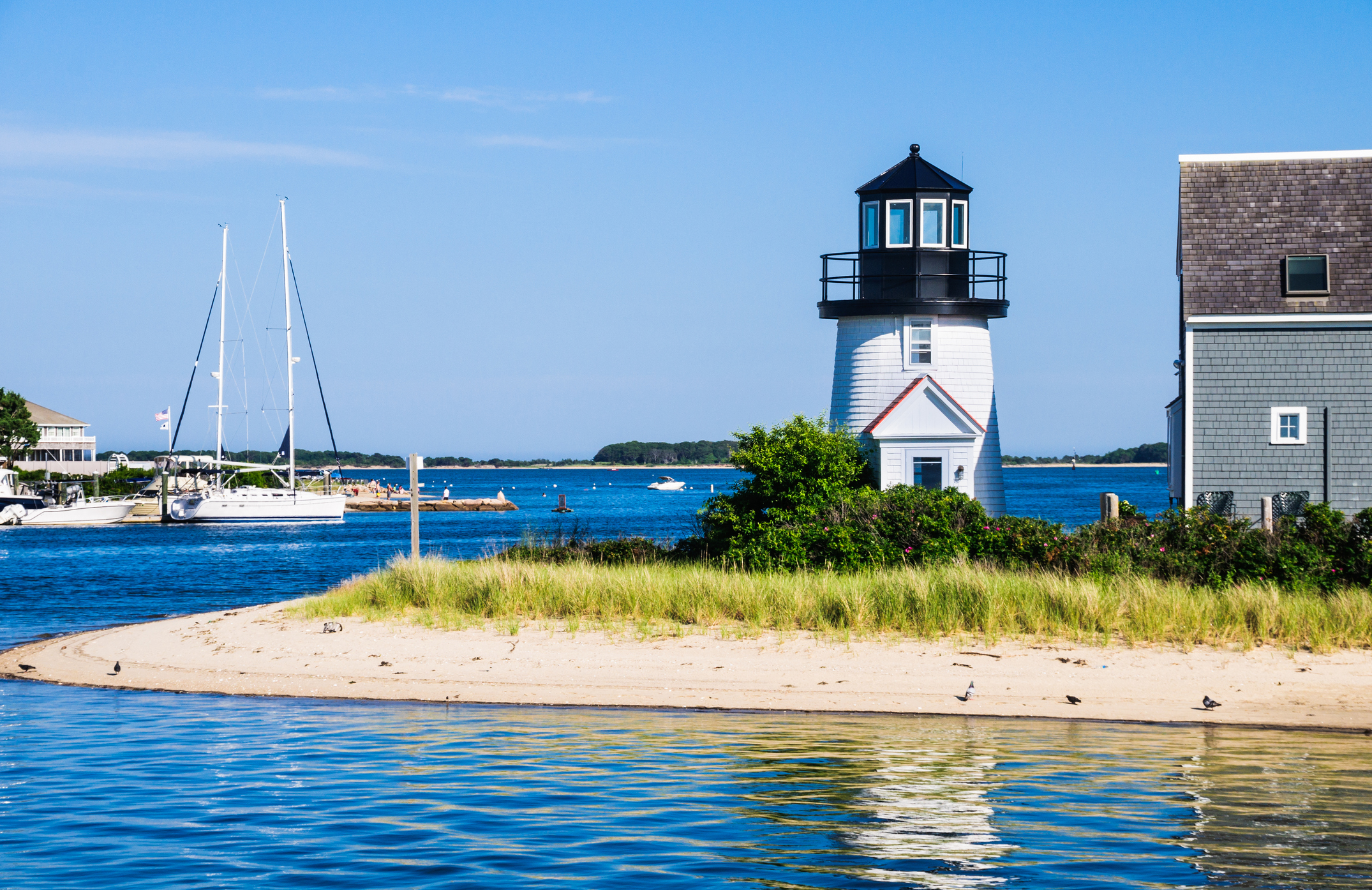 Hyannis Harbor Lighthouse on a sunny summer day with boats and blue water