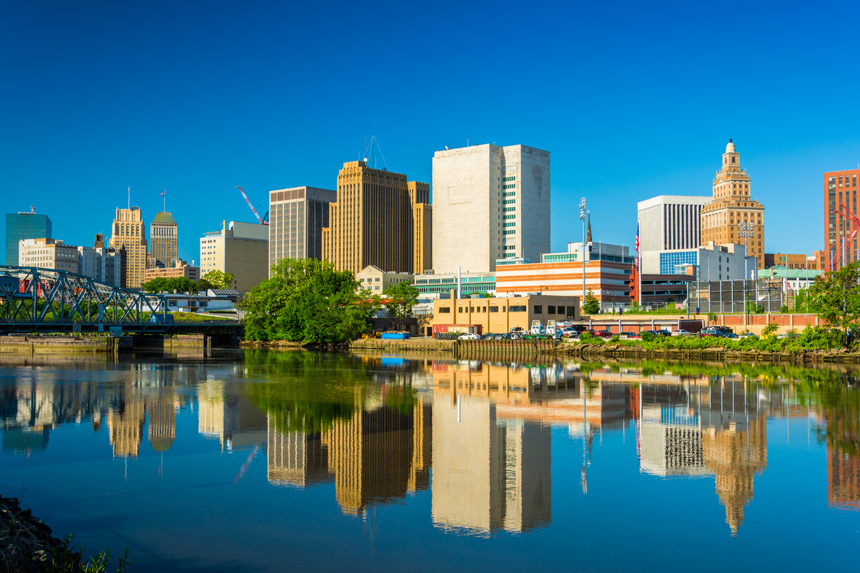 A view of downtown Newark, NJ, featuring the skyline reflected in the Passaic River, just steps from Newark Penn Station—Peter Pan Bus Lines’ drop-off location.