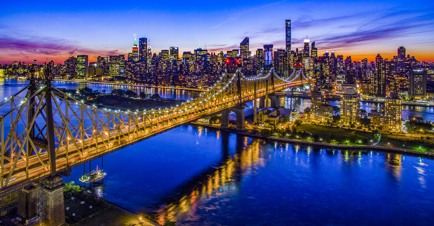 A sunset view of the New York City skyline and East River bridges—showcasing the destination at the end of your Hartford to NYC Peter Pan Bus ride.