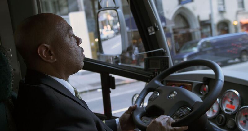 Peter Pan Bus Lines driver smiling behind the wheel of a motorcoach, highlighting professional driver careers.