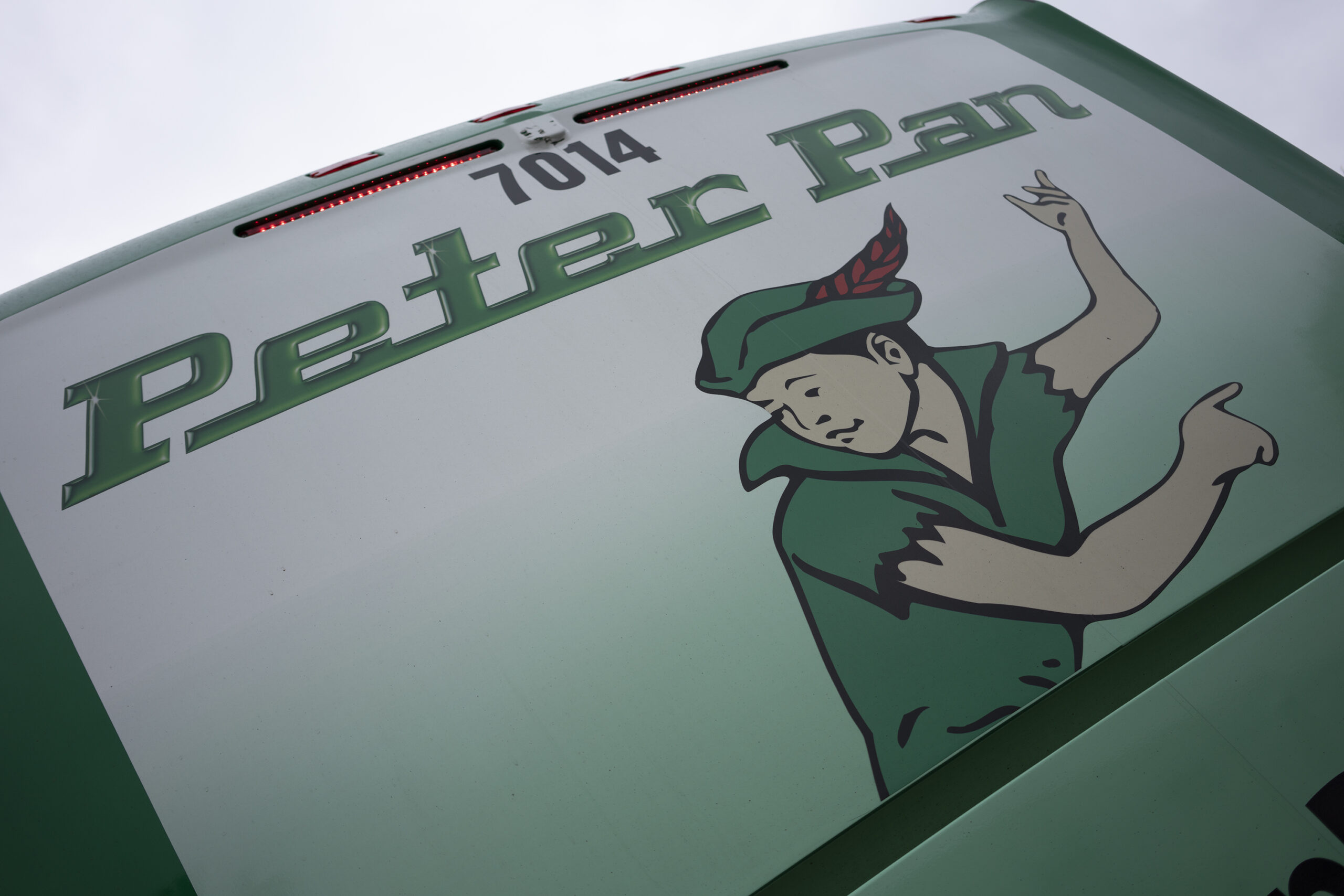 Close-up of the Peter Pan Bus Lines logo featuring the iconic Peter Pan character on the back of a green motorcoach.