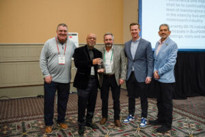 Tony Wilson of Peter Pan Bus Lines holds the ABA 2025 Driver of the Year award alongside industry leaders at the ceremony.