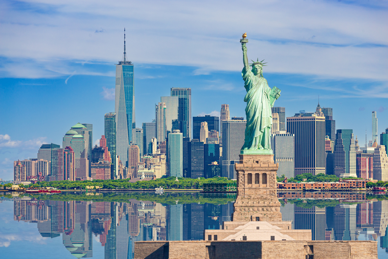 View of the Statue of Liberty with the Manhattan skyline in the background, representing a scenic arrival in New York City by Peter Pan Bus Lines.